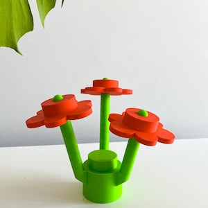 K&ouml;nnte beinhalten: Eine dreidimensionale Skulptur einer Blumenarrangements mit drei roten Blumen und gr&uuml;nen Stielen. Die Blumen haben eine abgerundete Mitte und f&uuml;nf Bl&uuml;tenbl&auml;tter. Die Stiele sind mit einer gr&uuml;nen Basis verbunden.
