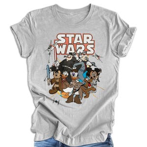 Pode incluir: Uma camiseta cinza com uma estampa gr&aacute;fica de personagens da Disney vestidos como personagens de Star Wars. O texto "STAR WARS" est&aacute; impresso em vermelho e branco acima dos personagens.