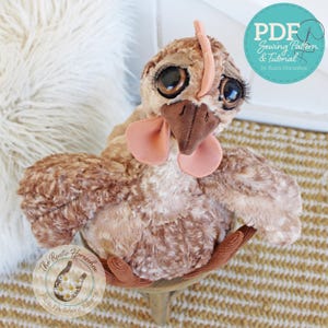 Puede incluir: Un juguete de peluche con forma de pollo marrón, con ojos grandes y oscuros, pestañas largas, pico marrón oscuro y barbillas de color rosa claro. El juguete tiene una tela suave y texturizada y una pequeña cresta. El texto dice PDF Sewing Pattern & Tutorial by Rustic Horseshoe.