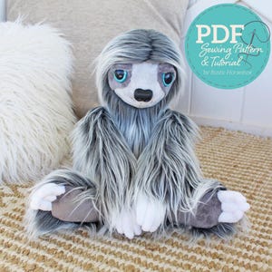 May include: A plush sloth toy with long, shaggy gray and white faux fur, large blue eyes, and a black nose. The toy has white paws and gray foot pads. A circular teal graphic in the corner displays the text PDF Sewing Pattern & Tutorial by Rustic Horseshoe.