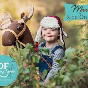 Puede incluir: Un niño con un gorro rojo y blanco con orejeras sostiene un juguete de montar de reno marrón. El juguete tiene una silla de montar de cuero marrón y una brida de cuero marrón. El niño está de pie en un entorno de bosque. El texto "Moose Ride-On Toy" se muestra sobre la cabeza del niño. El texto "PDF Sewing Pattern & Tutorial by Rustic Horseshoe" se muestra en un círculo azul debajo del niño.