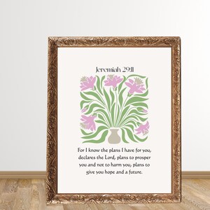 May include: A framed print with a gold ornate border. The print features a floral design in pink and green, with the text "Jeremiah 29:11" at the top. Below the floral design is a quote about hope and the future.