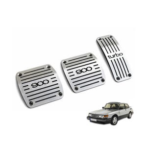 Puede incluir: Juego de tres cubiertas de pedales de coche plateadas con ranuras horizontales y el texto "900" y "turbo". Un coche Saab 900 plateado y negro está en la esquina inferior derecha.