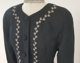 May include: A black blazer with silver embroidery. The embroidery features a floral design and a vine pattern.