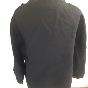 May include: Black long-sleeved jacket with a black lace collar.