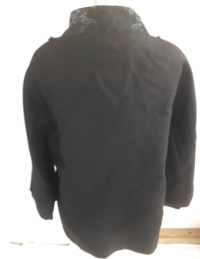May include: Black long-sleeved jacket with a black lace collar.