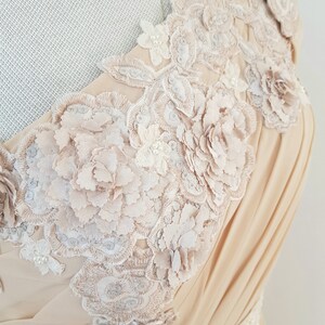 May include: A beige sleeveless dress with a delicate floral lace design. The lace features intricate details and a 3D effect, creating a romantic and elegant look.