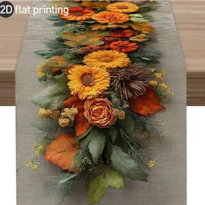 May include: A decorative table runner featuring a floral arrangement with orange and yellow flowers, green leaves, and brown accents. The runner is set on a neutral-toned surface, creating a warm, autumnal aesthetic. The words "2D flat printing" are in the top left corner.