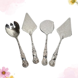 Peut inclure: Un ensemble de quatre ustensiles de service argentés avec des détails floraux ornés. L'ensemble comprend une fourchette à salade, deux pelles à gâteau et une pelle à tarte. Les manches ont un motif texturé en relief et les têtes de service ont un motif gravé délicat.