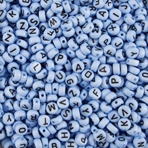 Könnte beinhalten: Ein großer Haufen hellblauer Kunststoffbuchstabenperlen. Die Perlen sind rund und haben schwarze Buchstaben darauf. Die Buchstaben sind alle unterschiedlich und zufällig angeordnet.