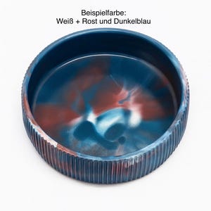 Op de afbeelding: Een ronde, decoratieve kom met een geribbelde buitenkant en een gemarmerd interieur. De binnenkant van de kom heeft een mix van blauwe, rode en witte kleuren. De tekst "Beispielfarbe: Wei&szlig; + Rost und Dunkelblau" is zichtbaar.
