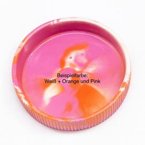 Op de afbeelding: Een ronde, decoratieve tray met een geribbelde oranje rand en een roze en oranje interieur. De tray heeft de tekst "Beispielfarbe: Wei&szlig; + Orange und Pink" in het midden. De tray staat op een witte achtergrond.