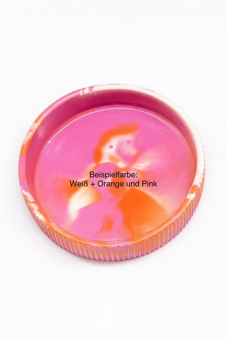 Op de afbeelding: Een ronde, decoratieve tray met een geribbelde oranje rand en een roze en oranje interieur. De tray heeft de tekst "Beispielfarbe: Wei&szlig; + Orange und Pink" in het midden. De tray staat op een witte achtergrond.