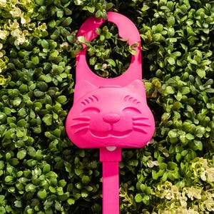 A magenta/pink Sidewinder smart cat toy.