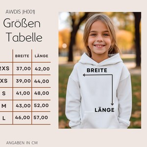 May include: A young girl wearing a white hoodie, with a size chart in German. The chart shows measurements in centimeters for width and length, ranging from 37 cm to 46 cm in width and 42 cm to 57 cm in length. The hoodie has a front pocket.
