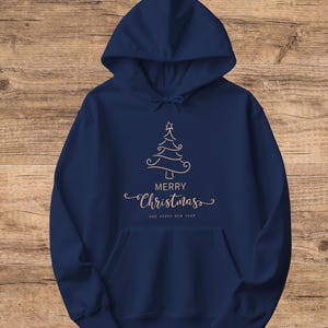 May include: Navy blue hooded sweatshirt with a front pocket and drawstring. The sweatshirt features a gold-colored Christmas tree design with the words "MERRY Christmas" and "AND HAPPY NEW YEAR" printed below the tree.