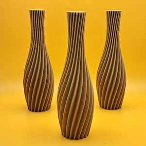 Könnte beinhalten: Drei braune Keramikvasen mit einem wirbelnden, strukturierten Design. Die Vasen sind in einer Reihe auf einer gelben Oberfläche angeordnet.