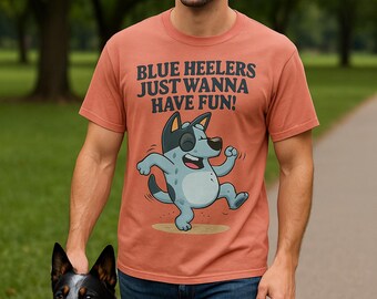 May include: Terracotta-colored t-shirt with the text "BLUE HEELERS JUST WANNA HAVE FUN!" and a cartoon Blue Heeler dog. The person is walking a Blue Heeler dog on a path.