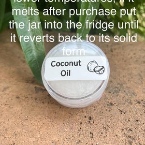 May include: A small, clear, round plastic jar containing white coconut oil. The label features the text 'Coconut Oil' and a small line drawing of a coconut. The text on the image reads: 'Coconut oil can melt at lower temperatures, if it melts after purchase put the jar into the fridge until it reverts back to its solid form'.