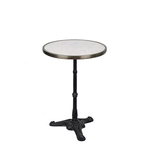 May include: A round white marble table top with a brass trim, supported by a black cast iron base with three legs.