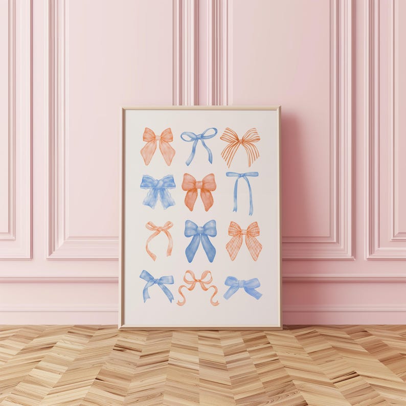 Peut inclure: Une affiche encadr&eacute;e pr&eacute;sentant des illustrations &agrave; l'aquarelle de n&oelig;uds dans des tons orange et bleu. Les n&oelig;uds sont dispos&eacute;s en grille sur un fond blanc. Le cadre est de couleur bois clair, et le fond est un mur rose.