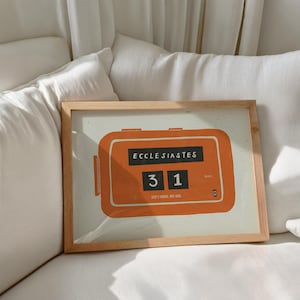 May include: A framed print with an orange retro-style counter illustration. The print displays the text "ECCLESIASTES" above the numbers "31". The text "GOD'S TIMING, NOT MINE" is also included.