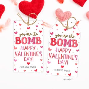 May include: Two Valentine's Day gift tags with the text "you are the BOMB. HAPPY VALENTINE'S DAY!" in red and pink. The tags are decorated with hearts and have a string for attaching. The size is 2"x3.5".
