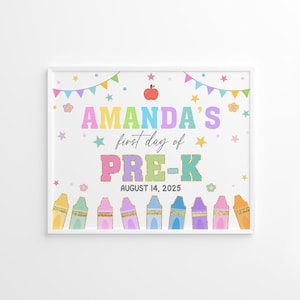 以下が含まれることがあります： カラフルな文字で「AMANDA'S first day of PRE-K AUGUST 14, 2025」と書かれた額入りのプリント。星、花、赤いリンゴ、クレヨンの列で飾られています。