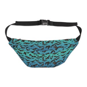May include: A fanny pack featuring a repeating pattern of dark brown bats against a gradient background that transitions from teal at the top to blue at the bottom. The bag includes a black adjustable strap with a plastic buckle and a zipper closure.