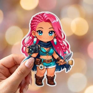 May include: A sticker featuring a cartoon character with pink hair, blue eyes, and teal clothing. The character holds a camera and a small shovel and brush. The character is wearing brown boots and a belt with a compass design.