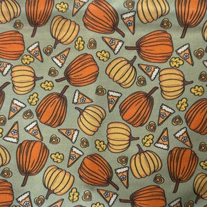 May include: A repeating pattern of orange and yellow pumpkins, pie slices, and fall leaves on a muted green background. The pumpkins vary in shape and size, with detailed stems. The pie slices have a crust and filling. The leaves are in shades of yellow and brown.