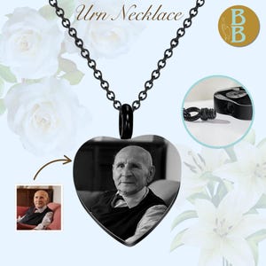 May include: Black heart-shaped urn necklace with a chain. The pendant features a black and white photo of an elderly person. The necklace includes a small, round, black urn and the words "Urn Necklace".