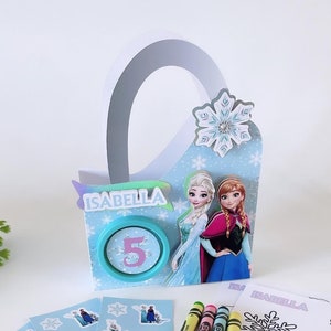 May include: A Frozen-themed party favor bag with a blue and white snowflake design. The bag has a handle and is decorated with images of Elsa and Anna. The bag also includes a sticker sheet with images of Elsa, Anna, and Olaf, four crayons, and a coloring page featuring Elsa.