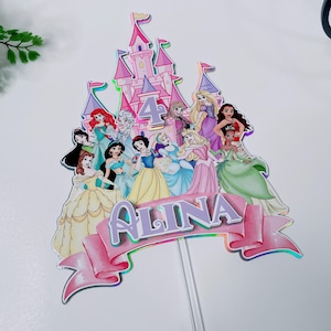 May include: A colorful cake topper featuring a pink castle with the number 4 and several princess characters. A pink banner with the name "ALINA" is at the bottom. The topper is on a clear plastic stick.