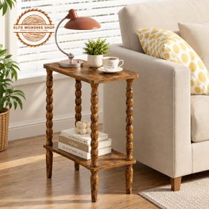 May include: A rectangular side table with a dark brown wood grain finish and four spindle-style legs. The table features a top surface and a lower shelf. The top holds a copper-coloured lamp, a small potted green plant, and a white coffee cup.