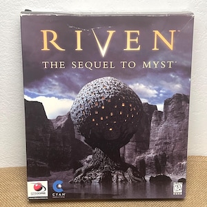 May include: Sealed Riven: The Sequel to Myst PC game box. The box art depicts a surreal landscape with a large, spherical structure atop a tree-like base, set against a dark, cloudy sky. The game title is in gold lettering.