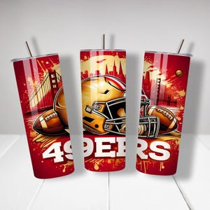 May include: Three red and white stainless steel tumblers with a graphic design of a football helmet, football, and the Golden Gate Bridge. The tumblers have the text "49ERS" printed on them.