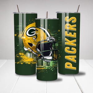 May include: Three green and yellow insulated tumblers with a football theme. One tumbler features a yellow football helmet with a green "G" logo. The other tumbler has the word "PACKERS" in yellow. Each tumbler has a straw.