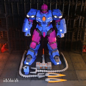 May include: A detailed robot action figure in blue and magenta armour, with multiple accessories. The figure has a complex design, with a hammer, cannon, and other weapon components. The text "TM 3D - 16 KOLARION" is visible at the bottom of the image.