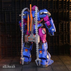 May include: A detailed robot toy in blue, purple, orange, and grey. The toy features a complex design with articulated joints and attachments, including a chain weapon. The text "TM30-16 KOLARION" is visible at the bottom of the image.