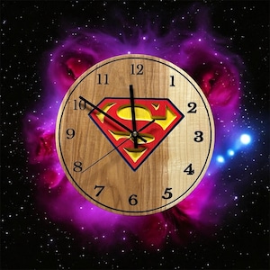 Pode incluir: Um relógio de madeira com um logotipo do Superman no centro. O mostrador do relógio tem números e ponteiros pretos. O fundo é roxo escuro com estrelas.