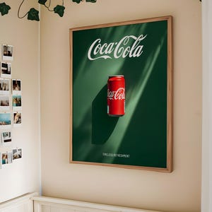 Puede incluir: Un póster enmarcado verde con el logotipo de Coca-Cola y una lata roja de Coca-Cola. El texto en el póster dice "Timeless Refreshment".