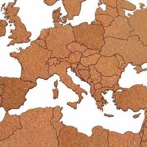 Pode incluir: Um mapa de parede da Europa e da região mediterrânica feito de material de cortiça castanha. O mapa apresenta fronteiras nacionais claramente definidas por linhas escuras, mostrando as formas geográficas dos países do continente.