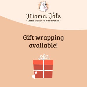 May include: A red gift box with a white ribbon and two white hearts on a light peach background. The text "Gift wrapping available!" is written in black above the box. The text "Mama Tale - Little Wonders Woodworks -" is written in black above the text "Gift wrapping available!"