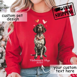Può includere: Felpa rossa con un design personalizzato per animali domestici per San Valentino 2025. La grafica mostra un Bracco tedesco con un collare floreale e dettagli a forma di cuore. È visibile anche il testo "your custom text here".