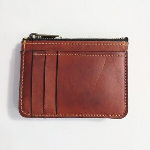 Una billetera de cuero genuino con múltiples compartimentos para tarjetas y monedas. Una billetera compacta con excelente almacenamiento de tarjetas y monedero.