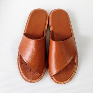 May include: A pair of brown leather slide sandals with a simple design. The sandals have a textured leather upper and a flat sole.