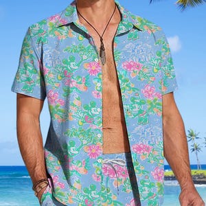 May include: A blue and green patterned short-sleeved shirt and matching shorts with a cartoon character design.