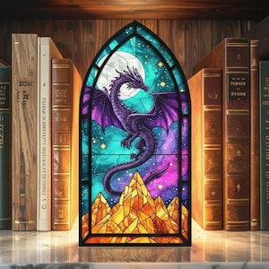 May include: A stained glass panel featuring a purple dragon with outstretched wings against a night sky with a full moon. The dragon is above a mountain range with yellow and orange hues. The panel is framed by a black border and set against a backdrop of antique books.