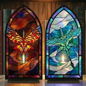 May include: Two stained glass window decorations. One features a red, orange, and yellow bird design, and the other has a blue and green creature design. Both have a candle in the center and are set in a black frame.